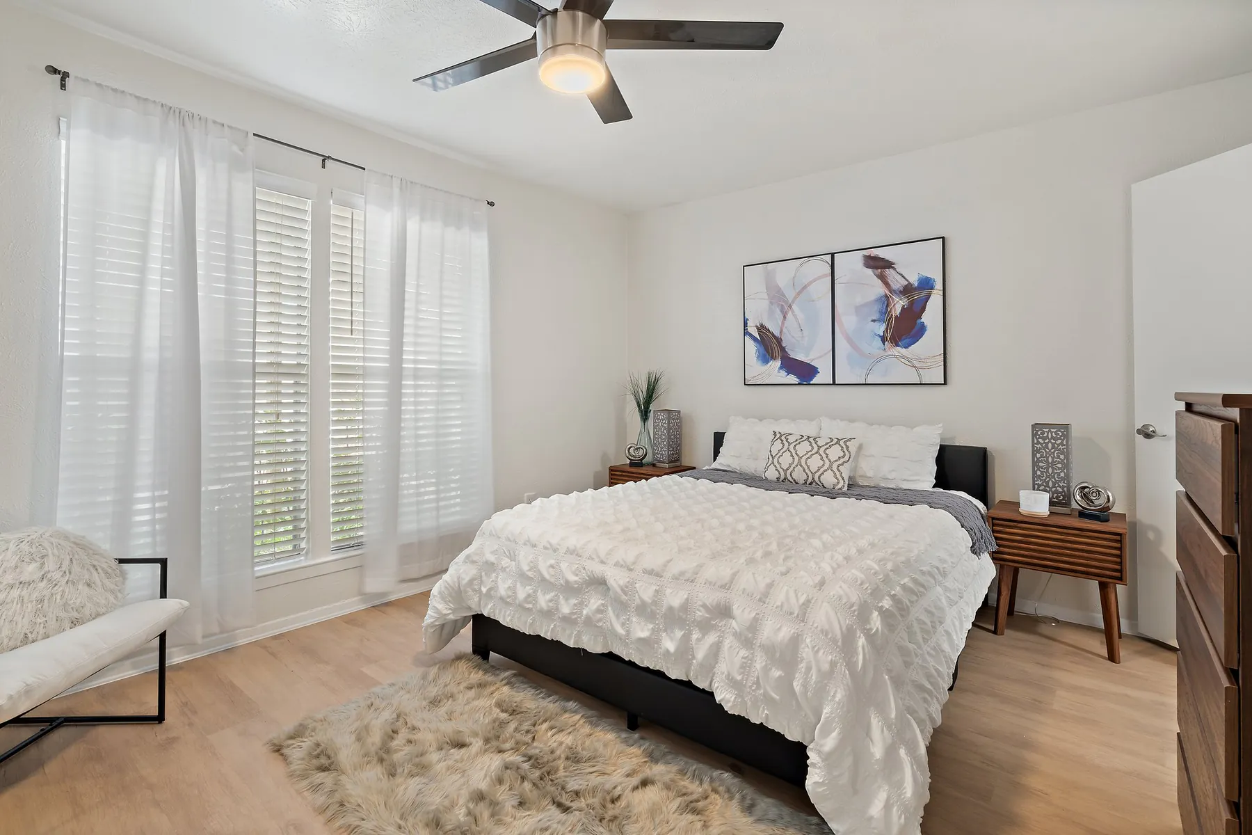 Bedroom with ceiling fan and shuttered windows at Regal Court