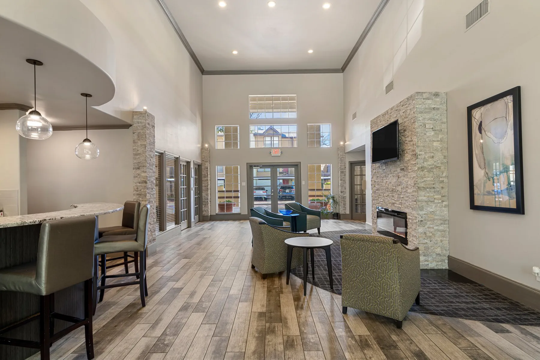Double-height clubhouse great room with tall windows and lounge seating at Regal Court