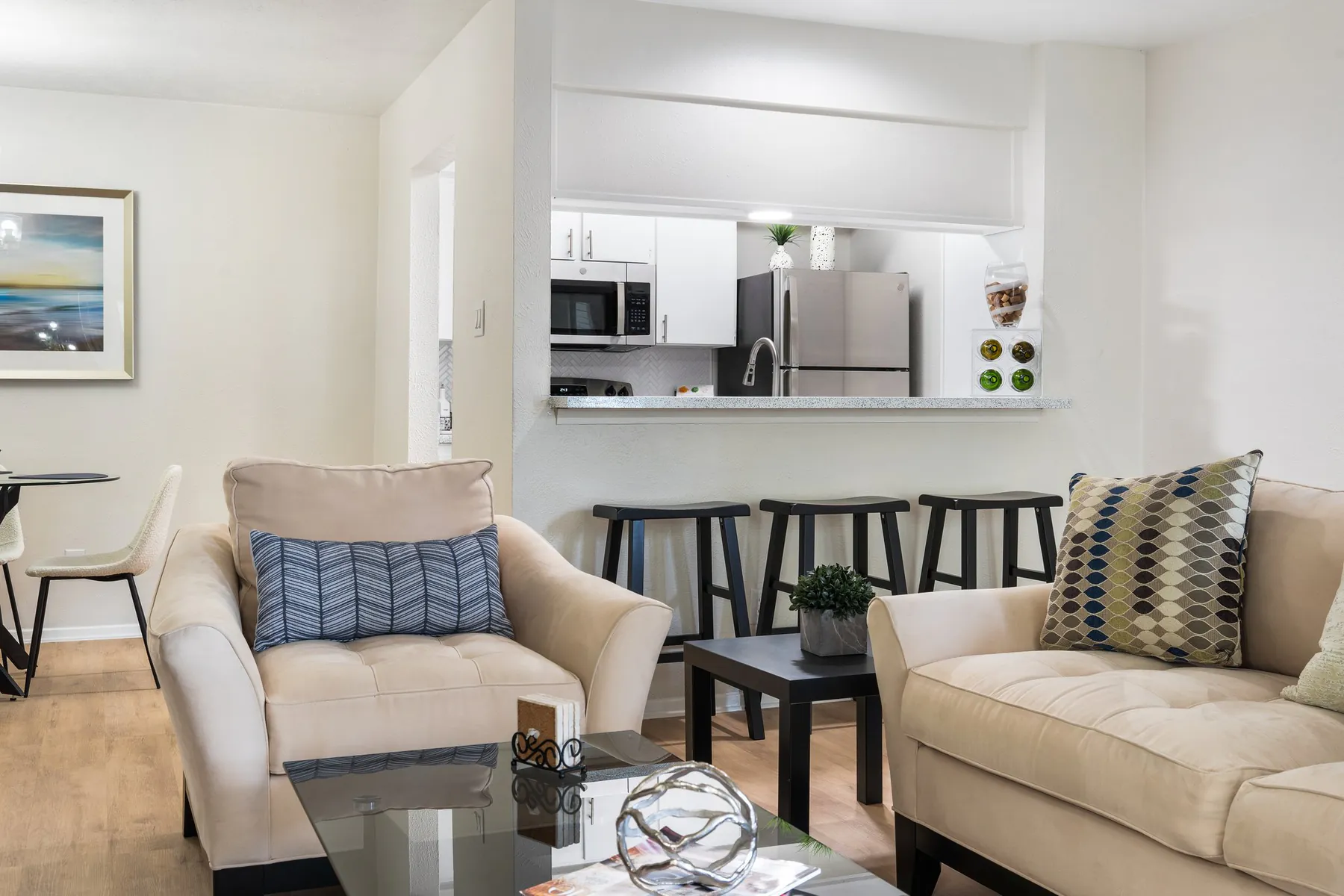 Furnished living room with kitchen pass-through breakfast bar at Regal Court