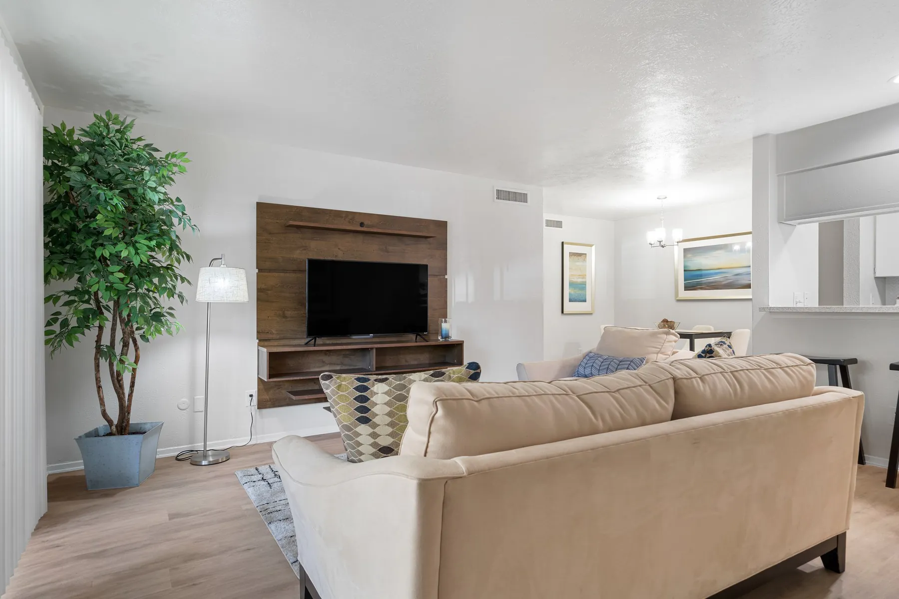 Living room with a wood-paneled television wall in a Regal Court apartment home